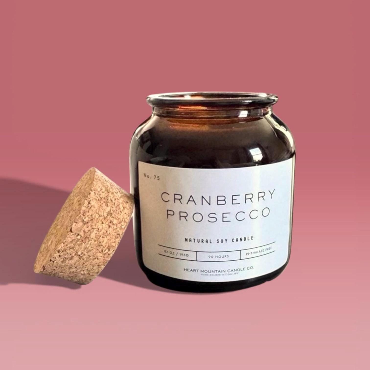 cranberry soy candle in amber apothecary jar with cork lid clean burning candle for home decor or gift for her prosecco fragrance candle with tart cranberry and bubbly prosecco notes in soy wax for an elegant cozy atmosphere 80 hour burn