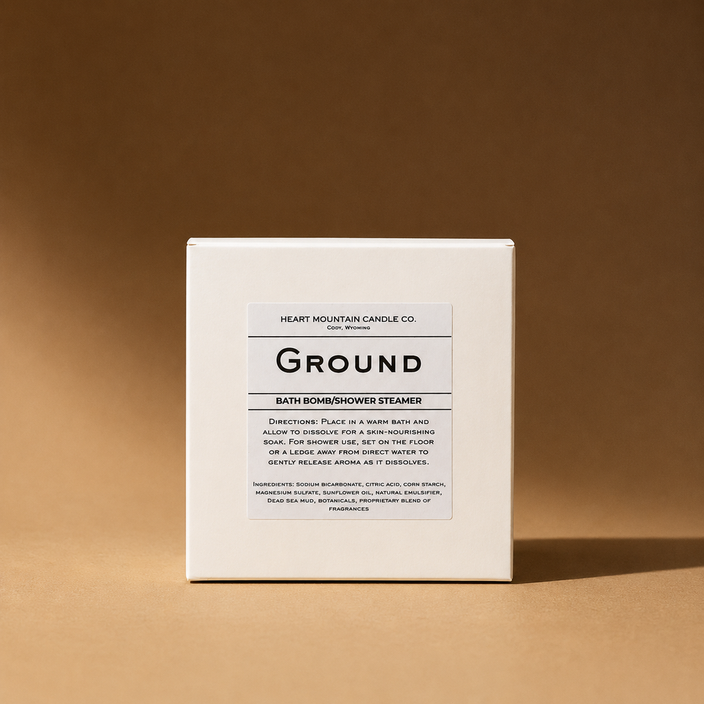A white box labeled 'Ground' bath bomb/shower steamer on a brown background.