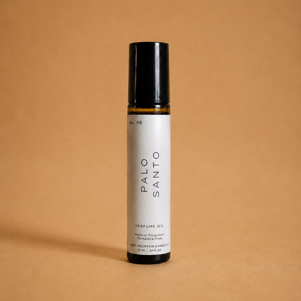 A Palo Santo perfume oil rollerball bottle on a tan background.