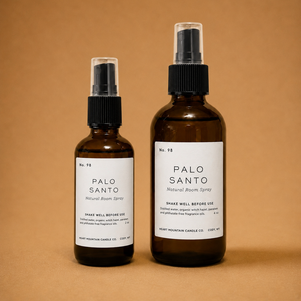 Two Palo Santo room spray bottles in different sizes on a tan background.