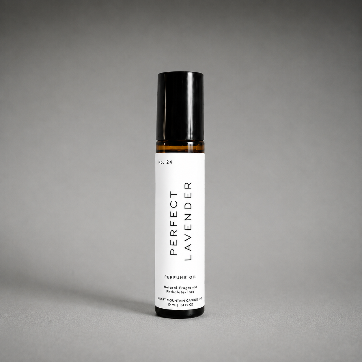 A Perfect Lavender perfume oil rollerball bottle on a gray background.