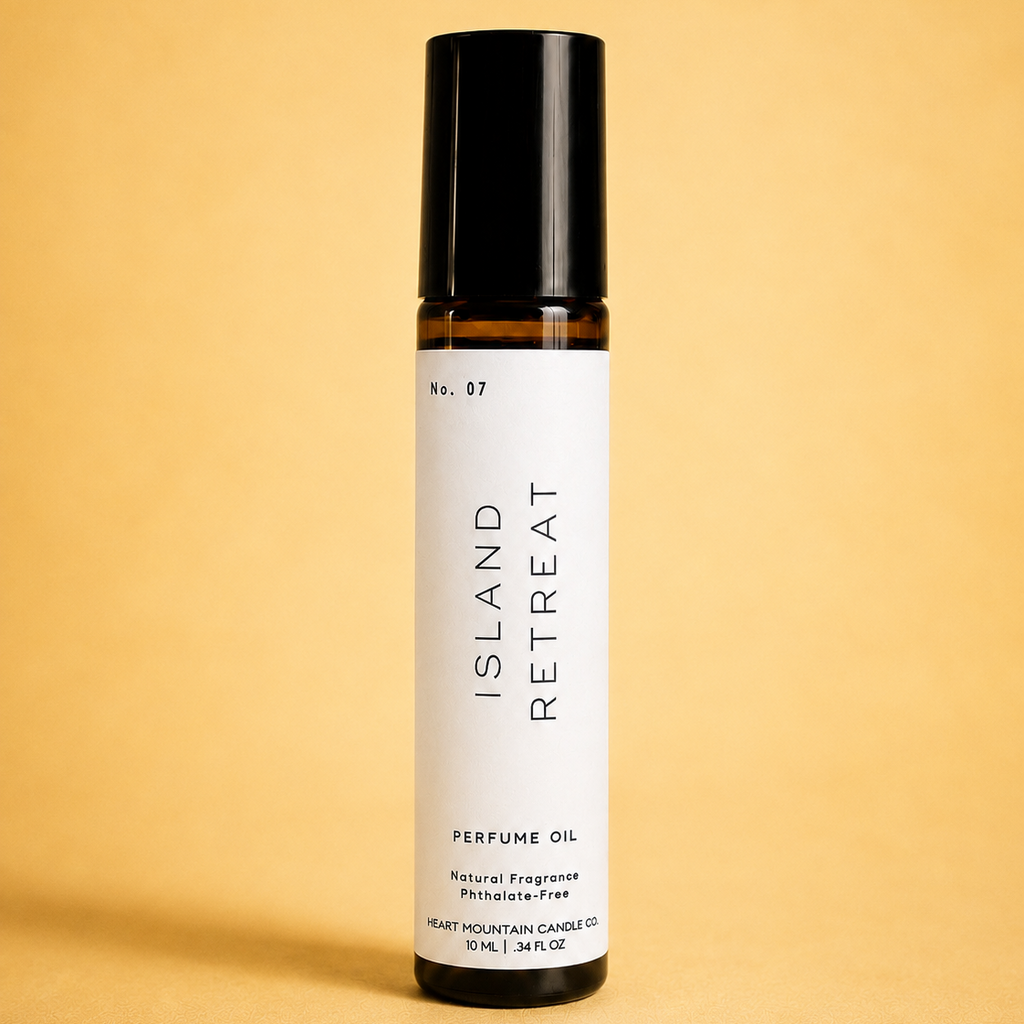 An Island Retreat perfume oil rollerball bottle on a yellow background.