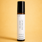 An Island Retreat perfume oil rollerball bottle on a yellow background.