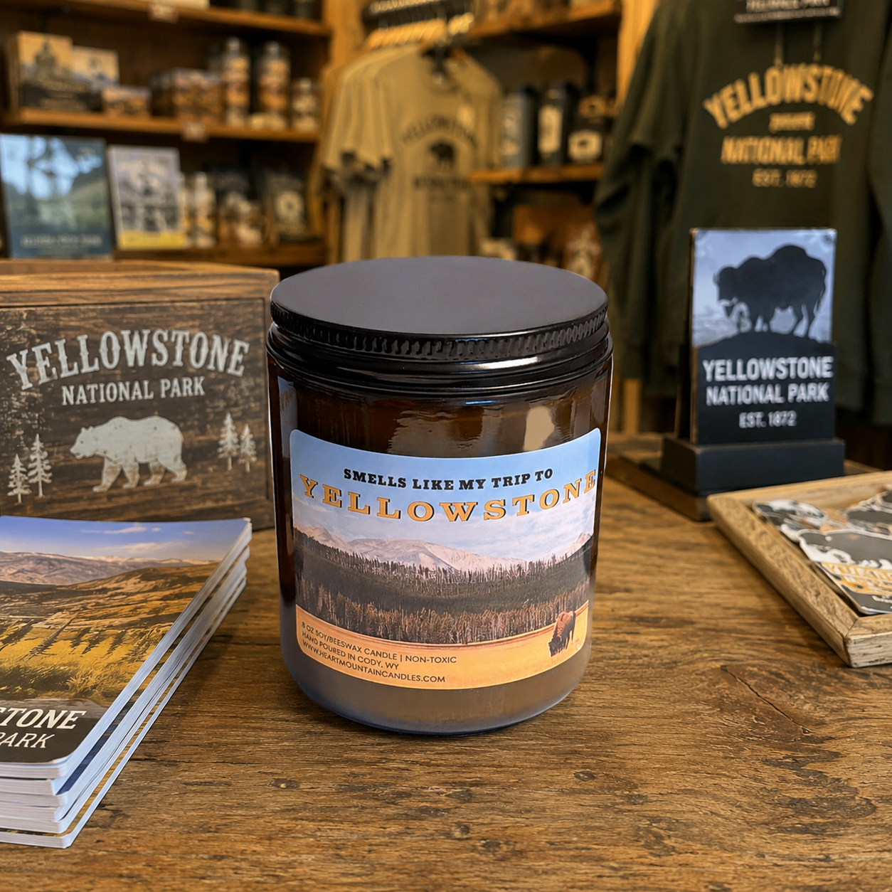 Yellowstone candle in amber glass jar styled in rustic national park inspired setting with earthy woods fresh trees dirt and mountain air fragrance cozy cabin decor candle for Yellowstone lovers Wyoming souvenir gift national park gift Christmas gift birthday gift Father’s Day gift housewarming gift anniversary gift gift for him gift for her outdoorsy gift for campers hikers travelers and adventure lovers clean-burning soy and beeswax candle with rugged wilderness inspired atmosphere